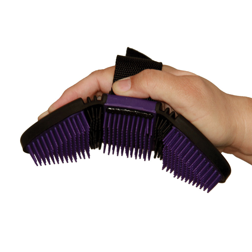 Hand holding a purple and black grooming brush on a white background