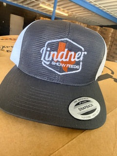 Trucker hat with 'Lindner Show Feeds' logo on a cardboard surface