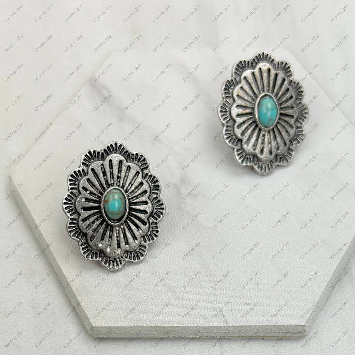 Silver earrings with turquoise stones on a white surface