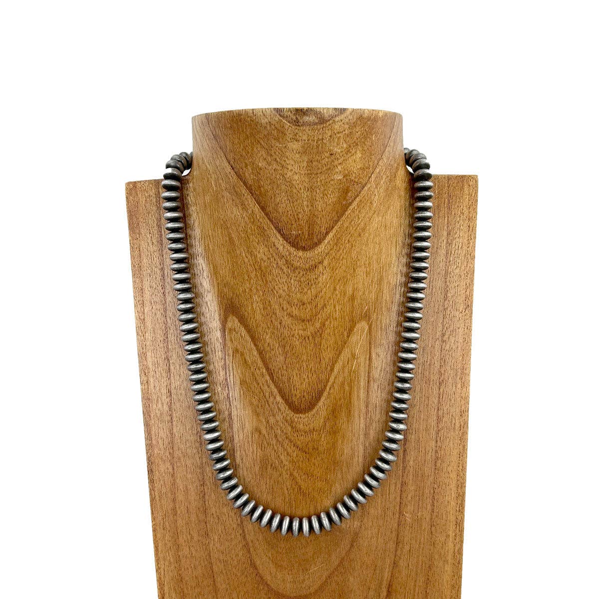 Necklace with silver beads on a wooden stand against a white background