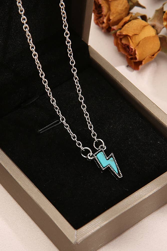 Necklace with a turquoise lightning bolt pendant on a black background