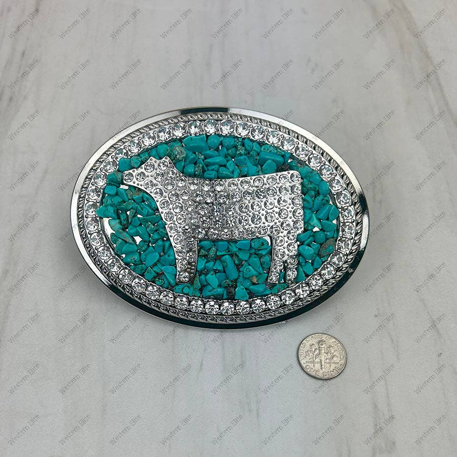 Decorative belt buckle with turquoise stone inlay and silver cow design, size comparison with a coin shown.