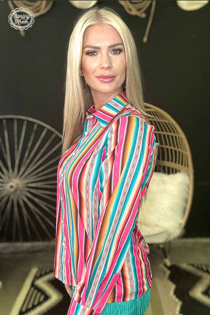Woman wearing a colorful striped shirt in a stylish interior setting