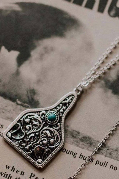Necklace with decorative pendant on a textured surface