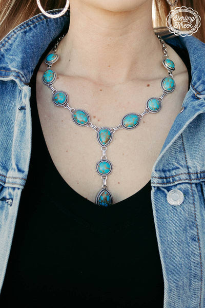 Turquoise necklace worn by a person with a denim jacket