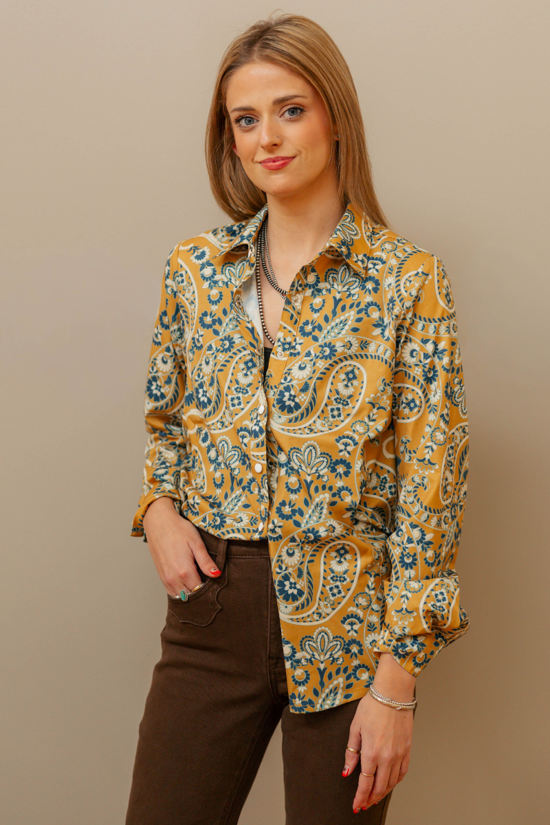 Woman wearing a patterned blouse against a beige background