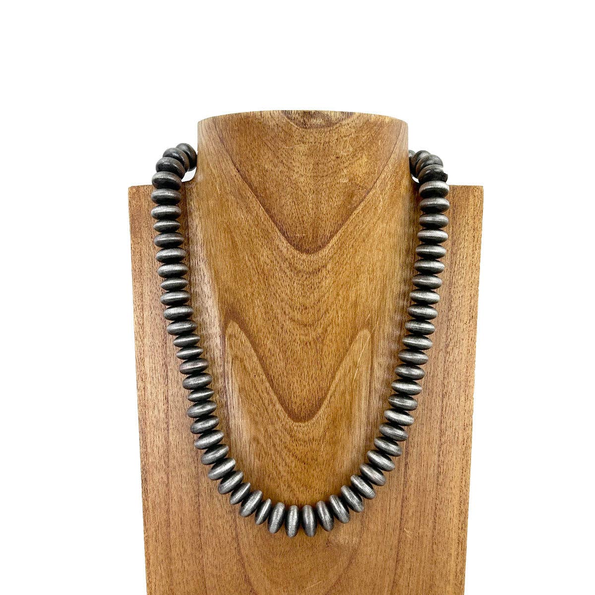 Necklace with metal beads on a wooden stand against a white background