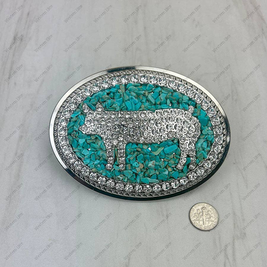 Turquoise and silver belt buckle with a coin for scale on a gray background