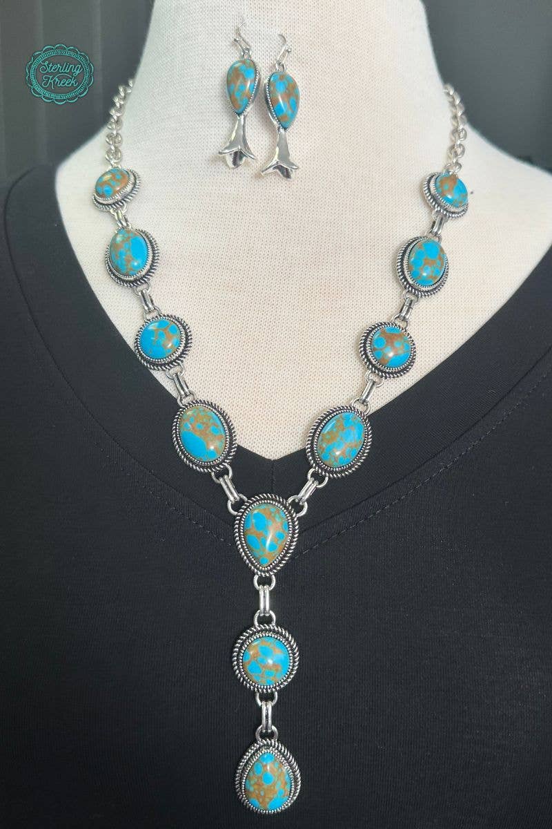 Turquoise stone necklace and earrings on a mannequin with a black background