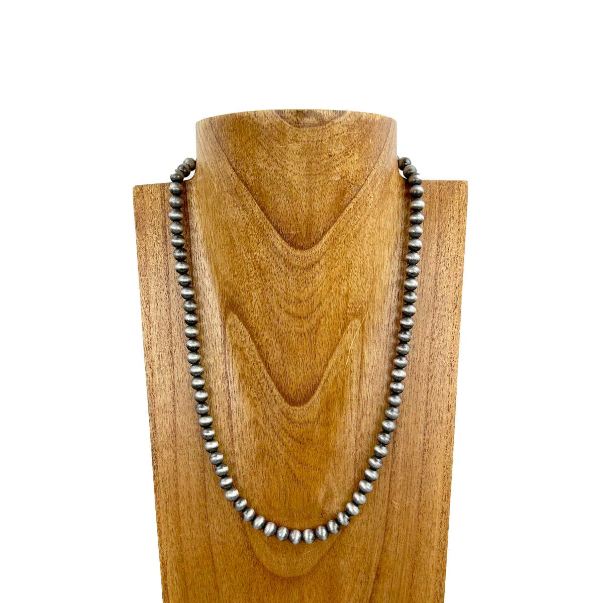 Necklace with silver beads on a wooden stand against a white background
