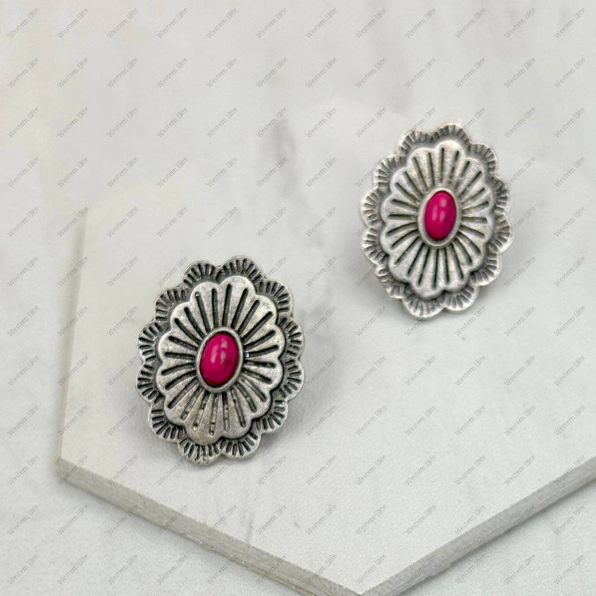 Silver floral earrings with pink centers on a white background