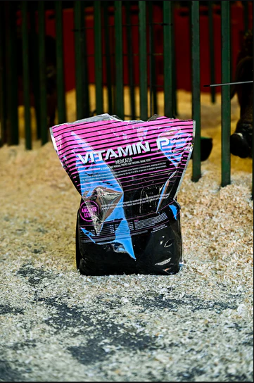 Vitamin supplement package on a gravel surface with a blurred background