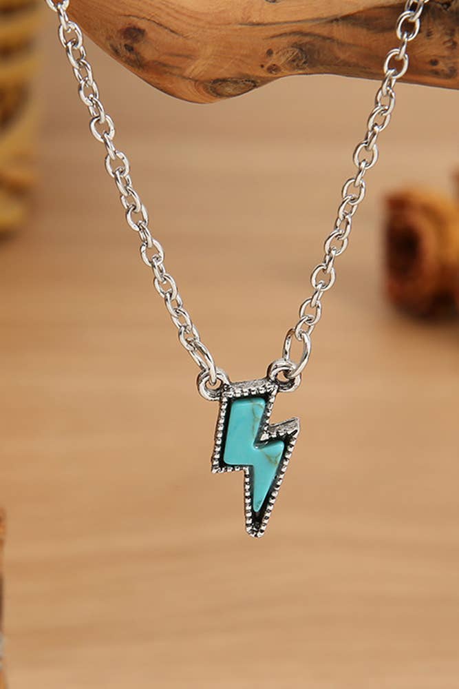 Necklace with a turquoise lightning bolt pendant on a wooden background