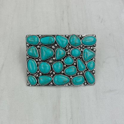 Turquoise stone belt buckle on a gray background