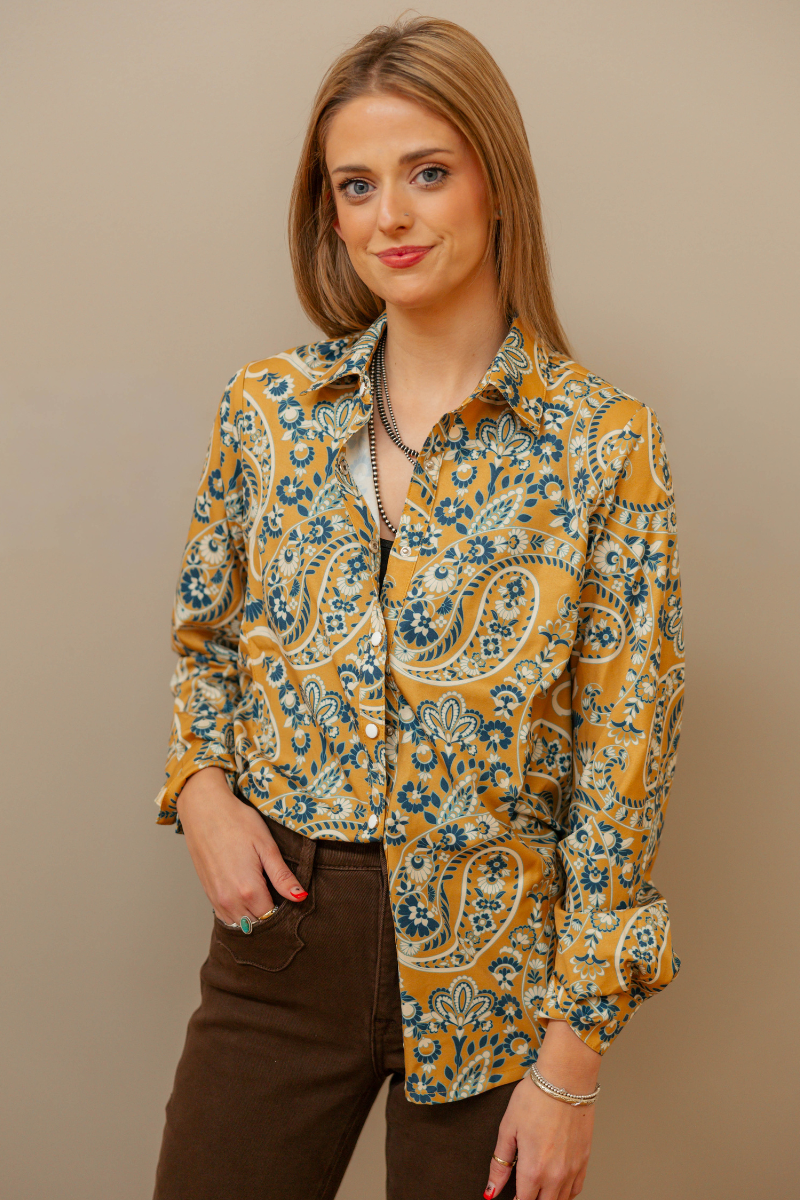Woman wearing a patterned shirt with a plain background